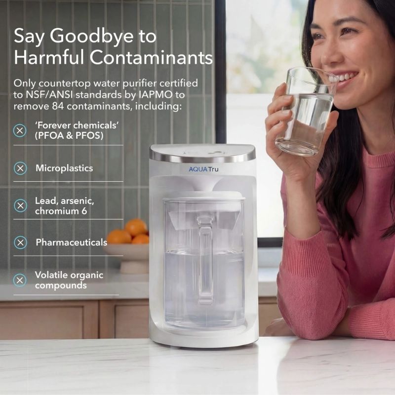 Woman holding a glass of water next to an AquaTru Carafe - Glass with text about harmful contaminants.