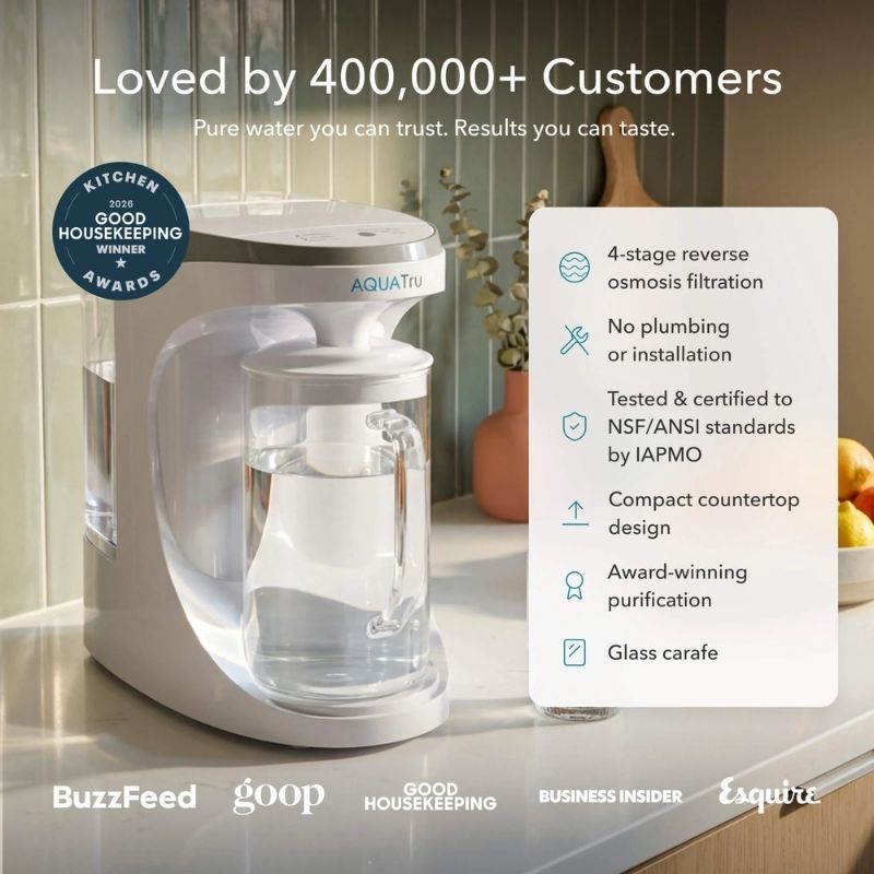 AquaTru Carafe - Glass on a kitchen counter with features listed on the right.
