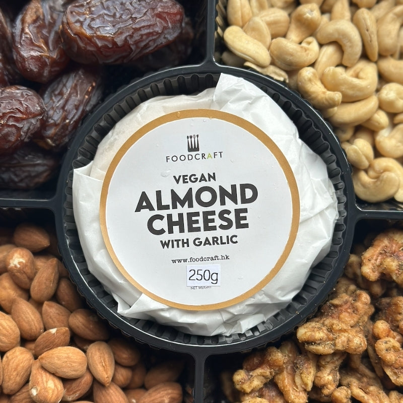 A round black tray holding a white-wrapped Vegan Almond Cheese with Garlic from Foodcraft, surrounded by nuts and dates in a grid layout.

Artisanal Gluten Free Vegan Cheese & Sprouted Nuts Platter - Almond Garlic Cheese
Foodcraft Online Store