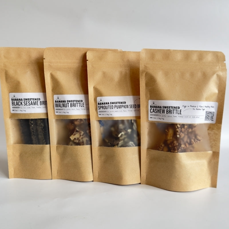4 Brown paper bags with a clear window containing all 4 Banana-Sweetened Sprouted  Brittles (Black Sesame, Walnut, Pumpkin Seed, Cashew)  on a white background
Foodcraft Online Store 