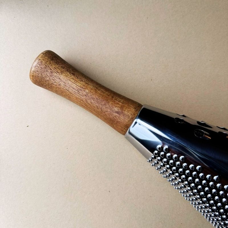 Conical Stainless Steel Grater with wooden handle on a beige background