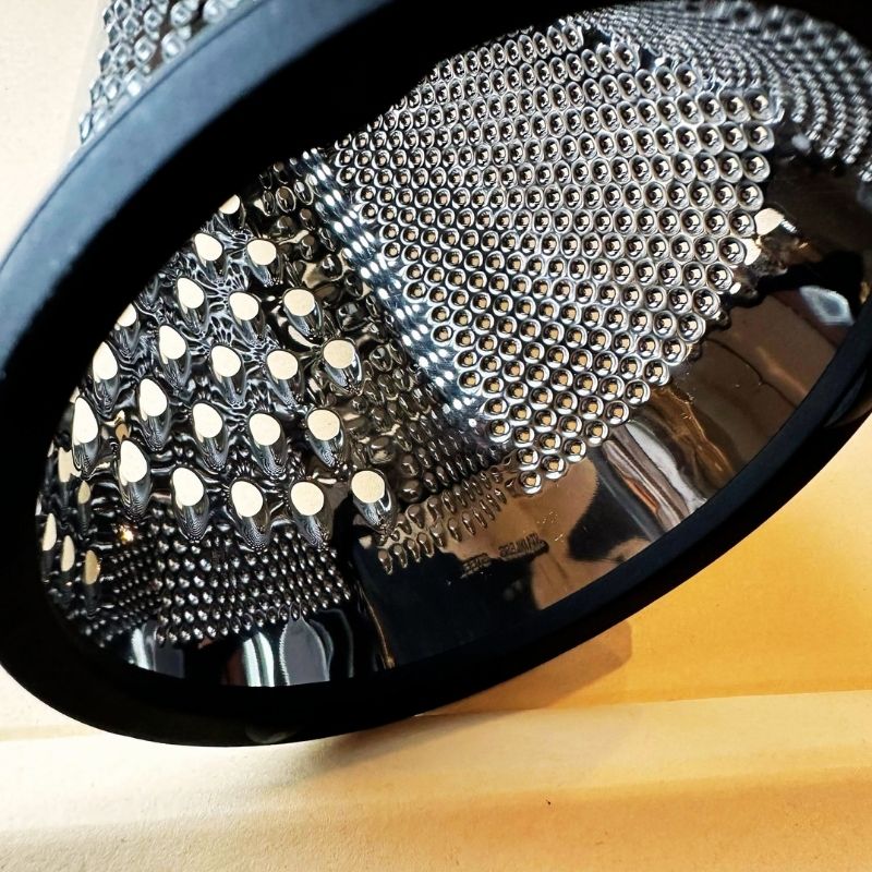 Close-up of a Conical Stainless Steel Grater on a beige surface