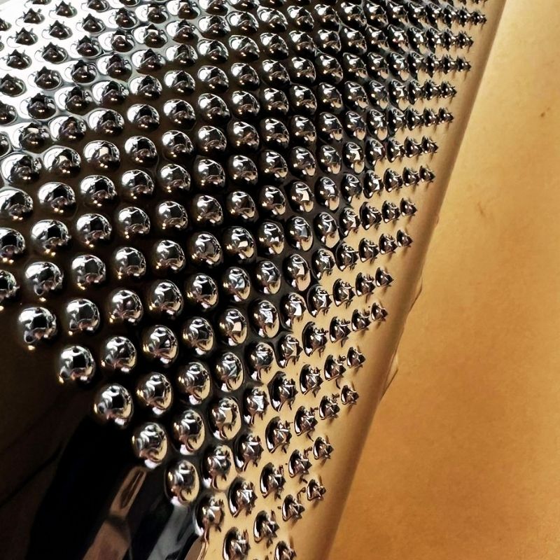 Close-up of a Conical Stainless Steel Grater with a beige background