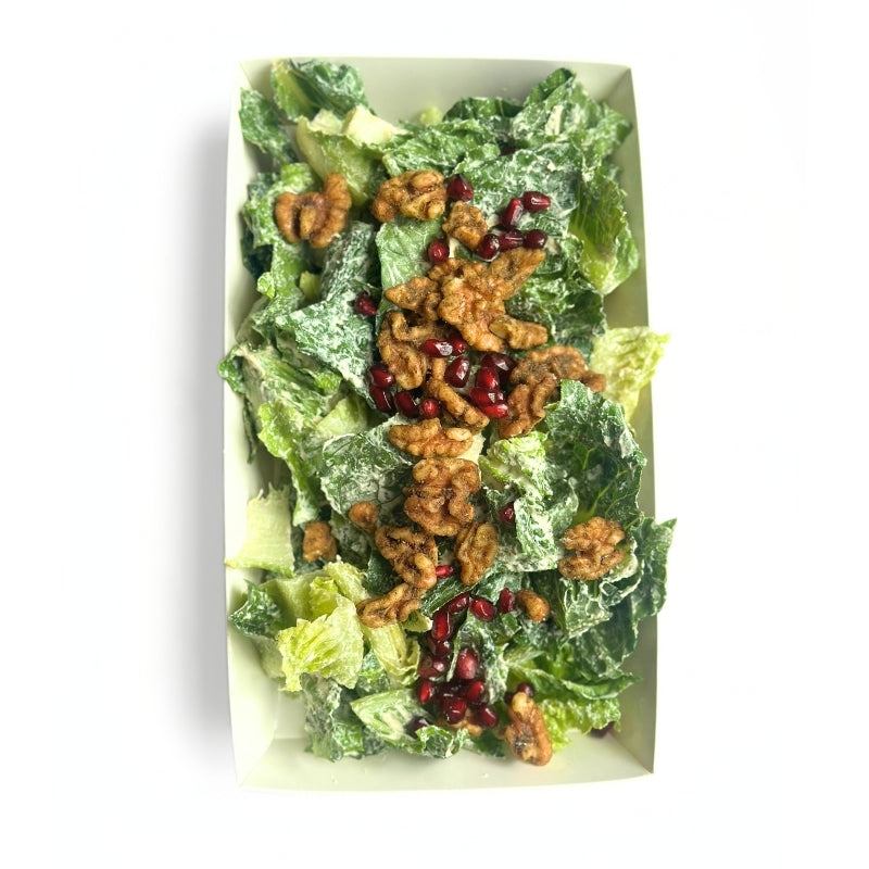 A top-down view of a Crispy Romaine Salad with Pomegranate, House Cashew Sour Cream & Garlic-Herb Sprouted Walnuts  in a white rectangular container, topped with walnuts and pomegranate seeds on a white background.
 (380g | Serves 4-6)
Foodcraft Online Store 