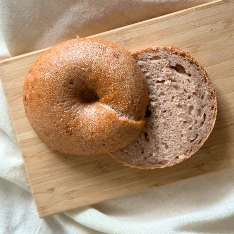 A sliced Gluten-Free Soft Original Sourdough Bagel -  piece on a wooden cutting board with a soft beige cloth underneath.

Gluten-Free Soft Original Sourdough Bagel  Set of 2 - FoodCraft Online Store