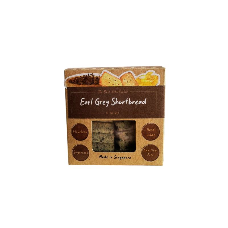 Box of I Quit Sugar Keto Earl Grey Shortbread with tea leaves and cookies on a white background