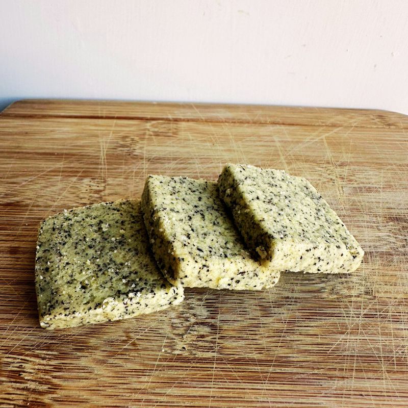 Three blocks of I Quit Sugar Keto Earl Grey Shortbread with specks on a wooden cutting board