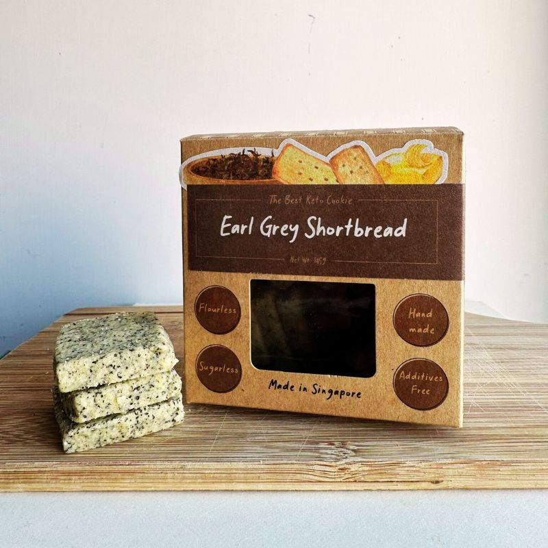 Box of I Quit Sugar Keto Earl Grey Shortbread cookies on a wooden surface with a white background