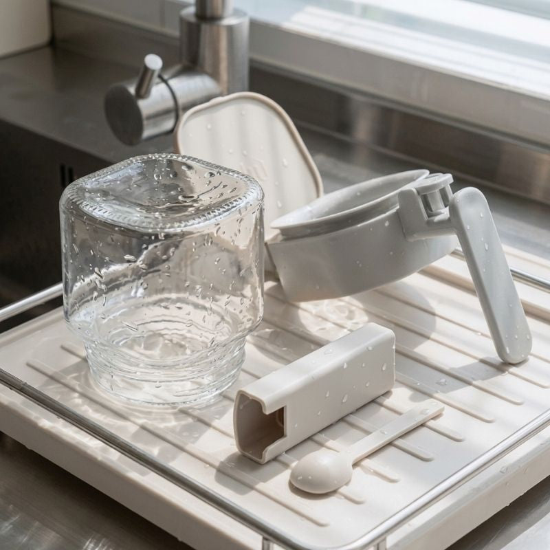 Japanese-Style Airtight Condiment Glass Pot - 300ml on a drying rack in a kitchen.