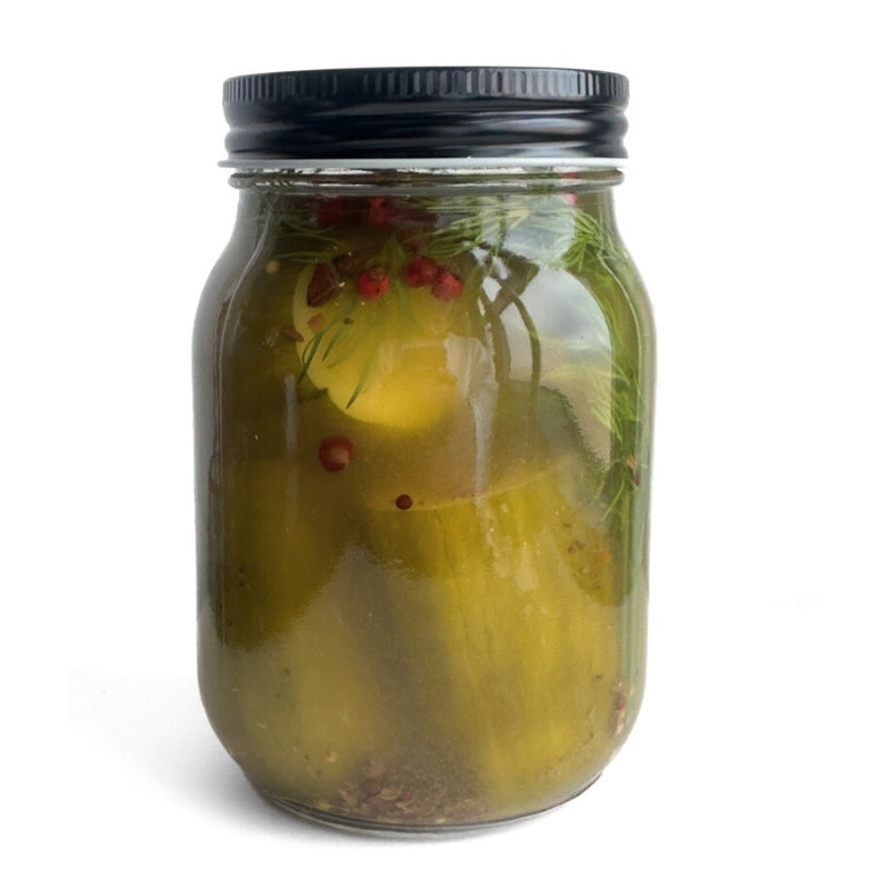 Jar of pickles with a black lid on a white background
