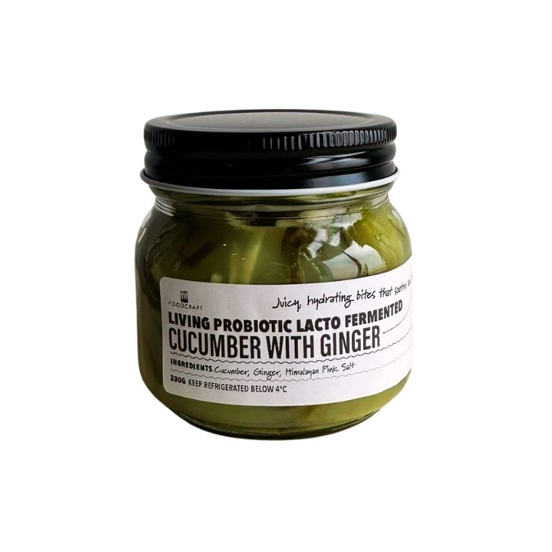 Jar of living probiotic lacto fermented cucumber with ginger on a white background