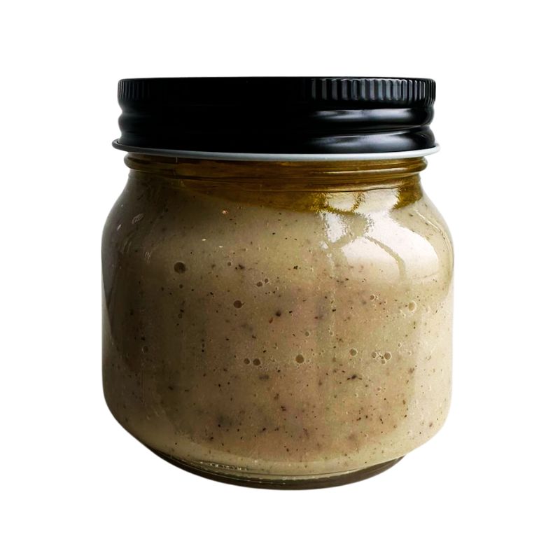 Jar of Living Lacto-Fermented Garlic Paste with a black lid on a white background
