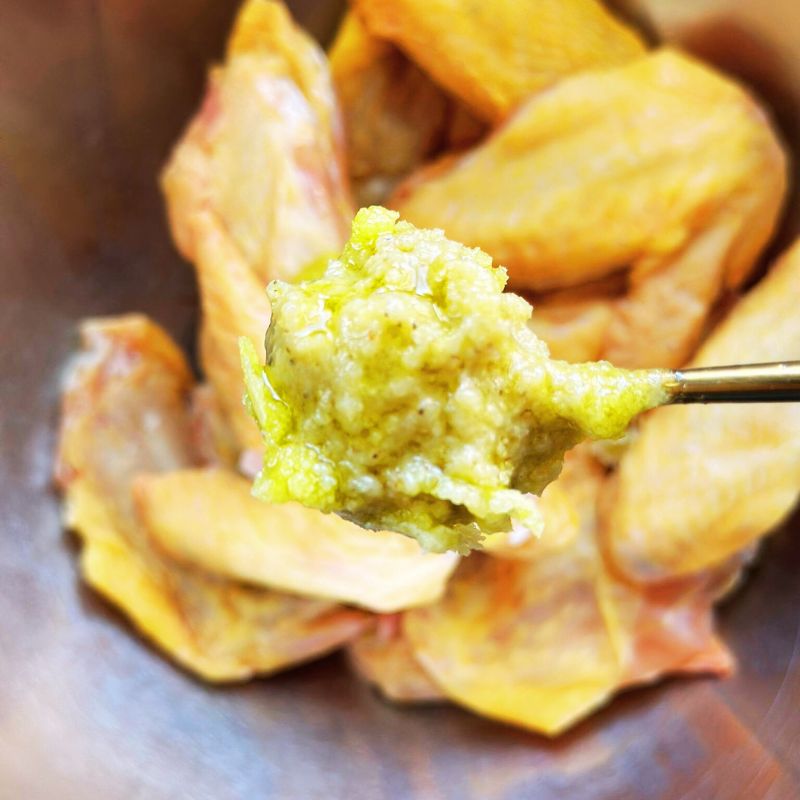 chicken wings with a spoonful of Living Lacto-Fermented Garlic Paste in a bowl