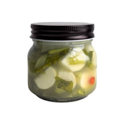 Jar of Living Lacto-Fermented Kabu Radish with Chili with a black lid on a white background