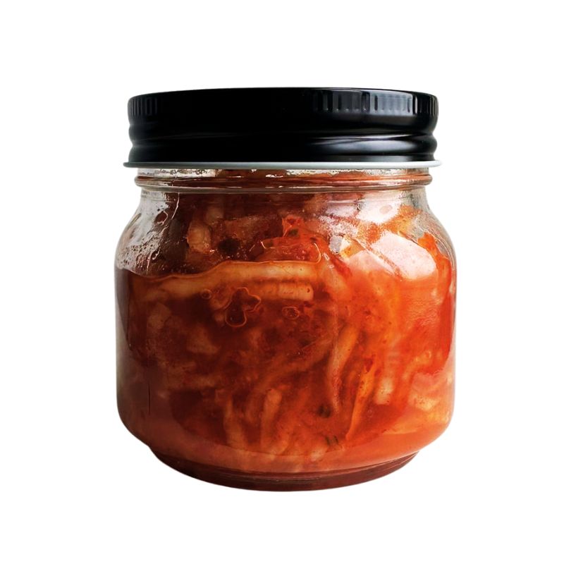 Jar of Living Lacto-Fermented Kimchee Daikon with a black lid on a white background