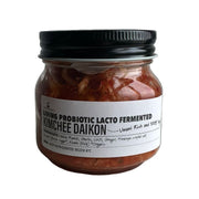 Jar of Living Probiotic Lacto Fermented Kimchee Daikon with a black lid on a light background