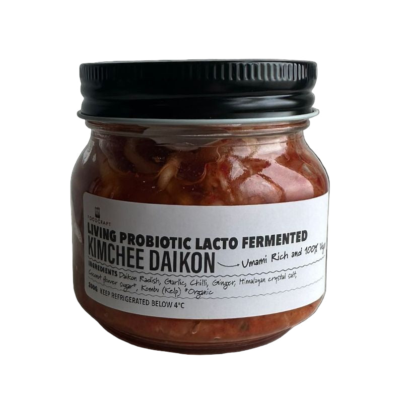 Jar of Living Probiotic Lacto Fermented Kimchee Daikon with a black lid on a light background