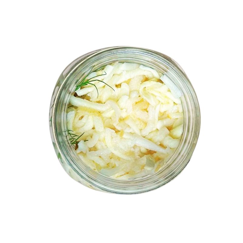 Glass jar filled withLiving Lacto-Fermented Parsnip and herbs on a white background