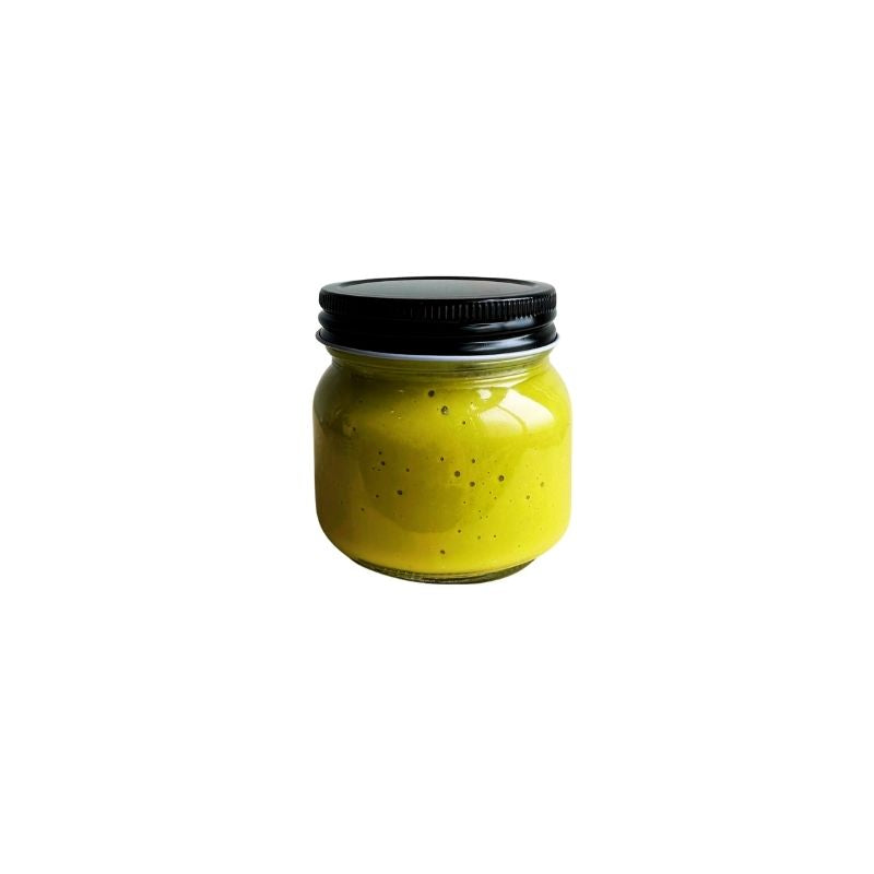 A small clear glass jar filled with Living Probiotic Creamy Jalapeno Sauce - 200g, sealed with a black metal screw lid, centered on a plain white background.