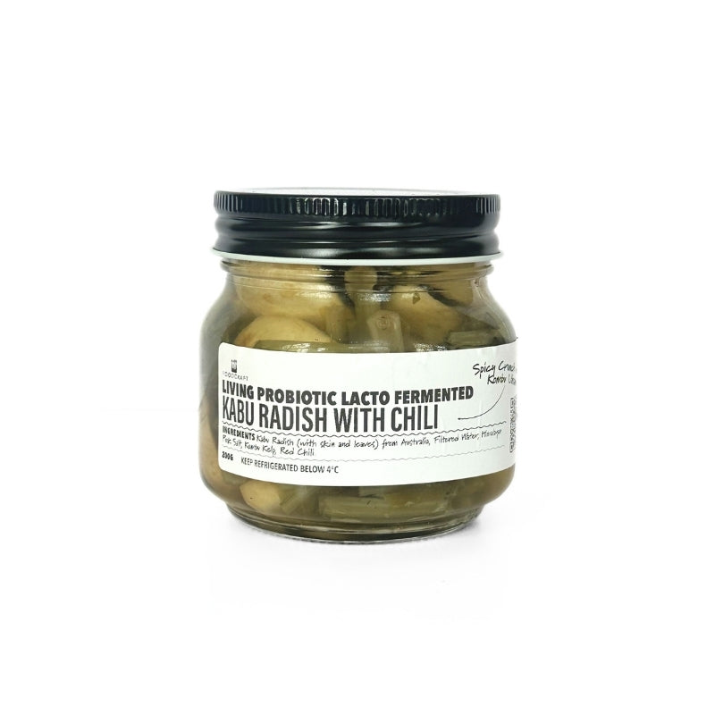 Jar of Living Lacto-Fermented Kabu Radish with Chili with a black lid on a white background