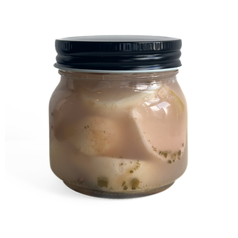 Jar of Living Lacto-Fermented Kabu Radish with Shiso with a black lid on a white background