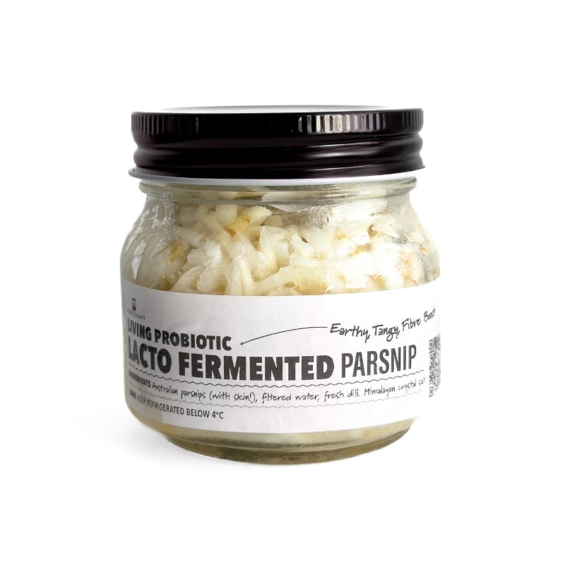 Jar of lacto-fermented parsnips with a black lid on a white background