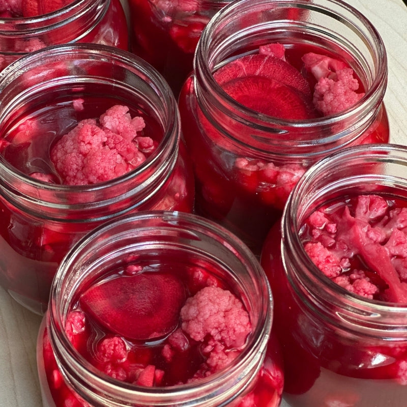 Jars of Living Lacto-Fermented Cauliflower & Purple Carrots with Sumac on a white plate