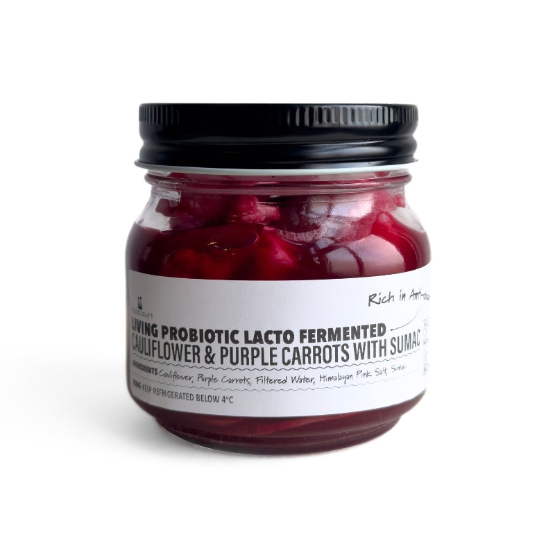 Jar of Living Lacto-Fermented Cauliflower & Purple Carrots with Sumac with a black lid on a white background