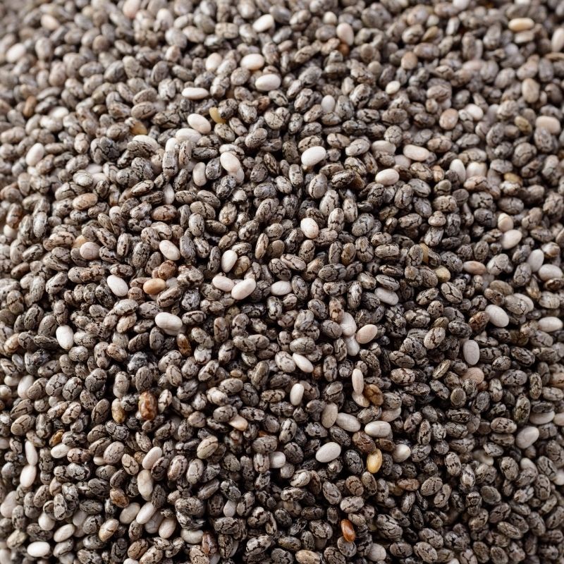 Close-up of chia seeds with a mix of brown, white, and gray colors.