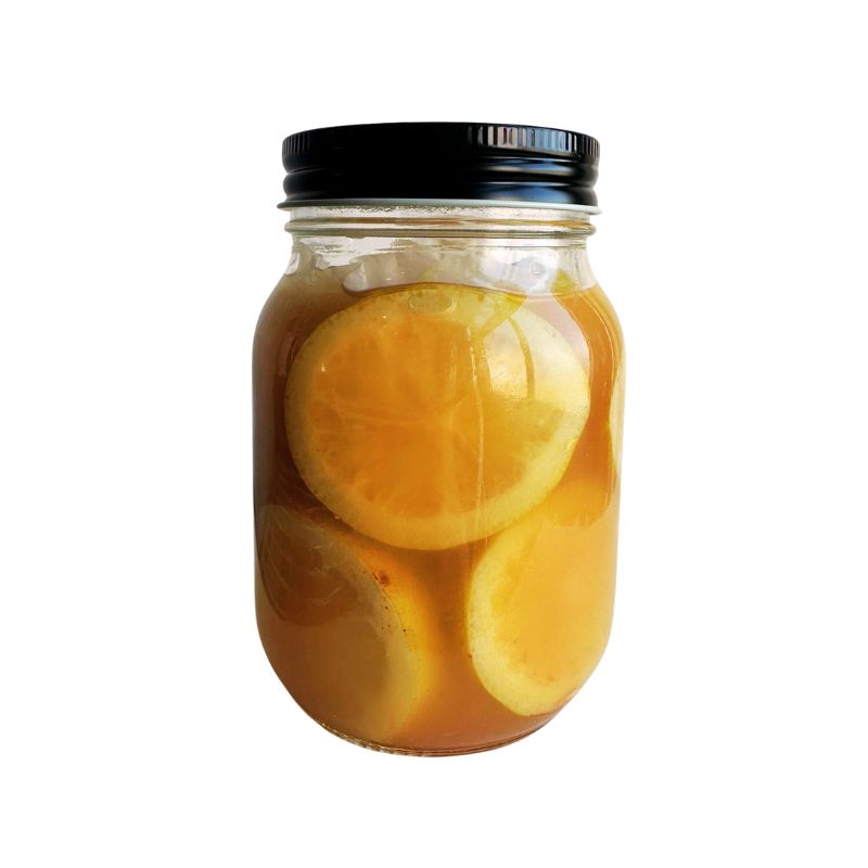 Mason jar filled with Organic Salted Lemon (pickled lemon) and a black lid on a white background