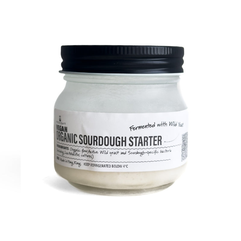 Jar of organic sourdough starter with a black lid on a white background