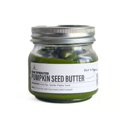 Jar of raw sprouted pumpkin seed butter with a metal lid on a white background
