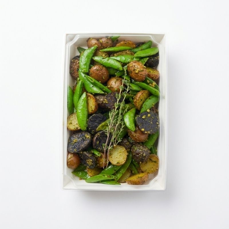 A top-down view of the packaging sample image for Roasted Potato Salad with Sprouted Walnut Pesto -  (600g | Serves 3 – 6 people). A white rectangular container filled with Roasted Potato Salad with Sprouted Walnut Pesto on a clean white background.