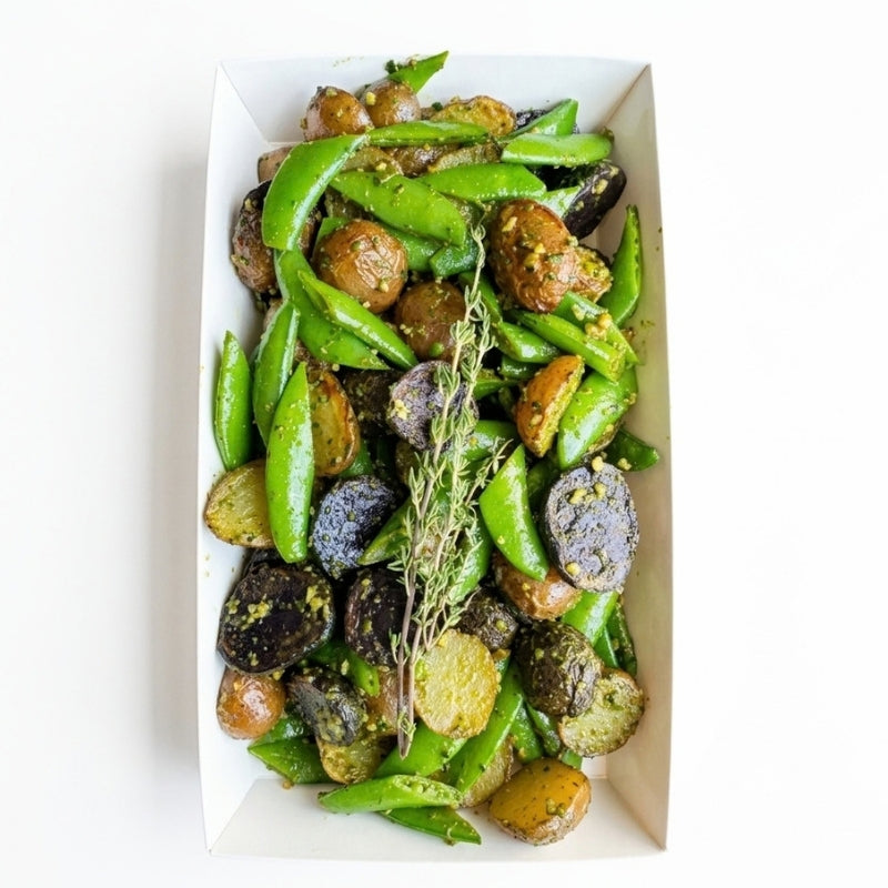 A top-down view of a white cardboard food tray filled with Roasted Potato Salad with Sprouted Walnut Pesto -  (600g | Serves 3 – 6 people) on a white background.

Foodcraft Online Store
