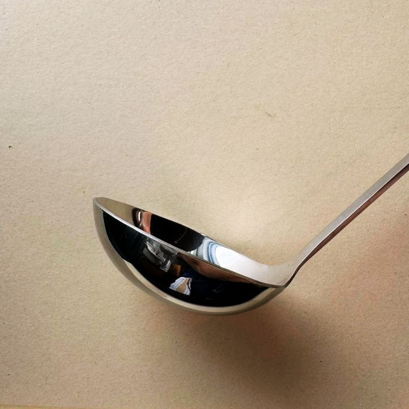 Stainless Steel Ladle and Strainer Pot Spoon Set on a beige background