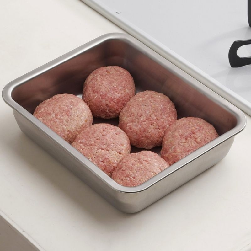 Six raw ground meatballs in Stainless Steel Storage Prep Tray with Lid (Wide Deep Size) on a white countertop.