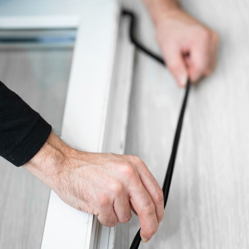 Close-up of hands holding UNOX Spare Parts Door Gasket Kit - KGN1230A against a white curtain background