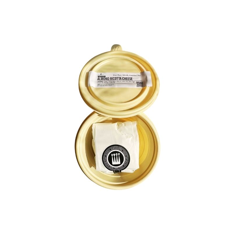 Beige container with a block of Foodcraft Vegan Almond Ricotta Cheese on a white background