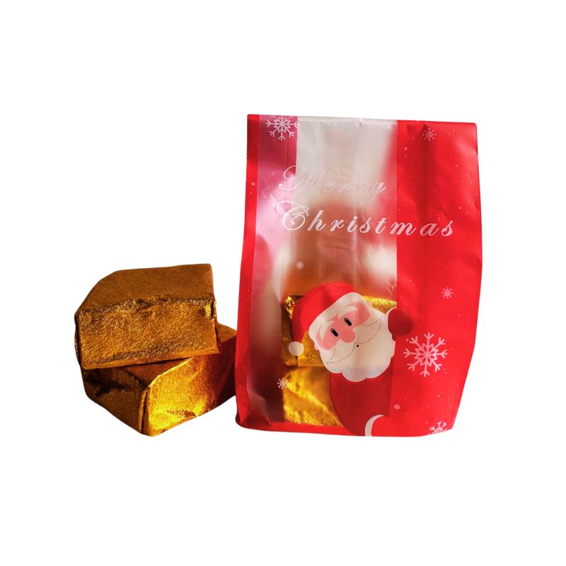 Red Christmas-themed bag with Vegan Gluten-Free Winter Brownie next to gold foil-wrapped brownies on a white background